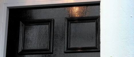 A black door with a sign above it that reads 'Ninety One Apartment Hotel Jesmond Road.'
