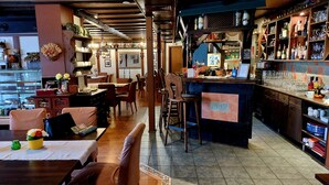 Een restaurant met een bar, houten meubels en uitzicht op de stad.