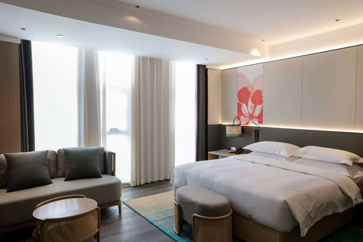Une chambre d’hôtel moderne avec un lit, un canapé et une petite table.