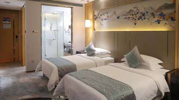 Habitación de hotel con dos camas, baño y decoración en la pared.