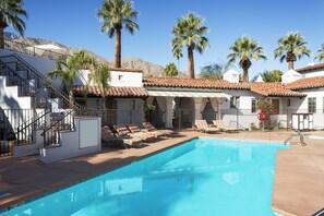 A pool area with lounge chairs and a staircase leading to a building. - Triada Palm Springs, Autograph Collection by Marriott (Palm Springs)