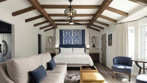 Une chambre moderne avec un grand lit, un canapé, un fauteuil et une petite table.