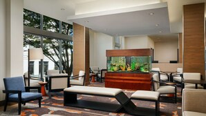 A modern lobby with seating, a large aquarium, and large windows. - Hyatt House Atlanta Downtown (Atlanta)