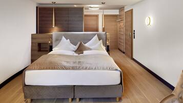 Een moderne slaapkamer met een groot bed, houten hoofdeinde en een inbouwkast.
