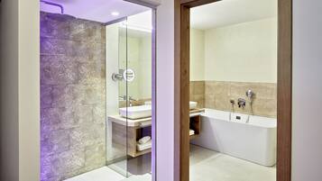A modern bathroom with a glass-enclosed shower, a freestanding bathtub, and a vanity with a mirror.