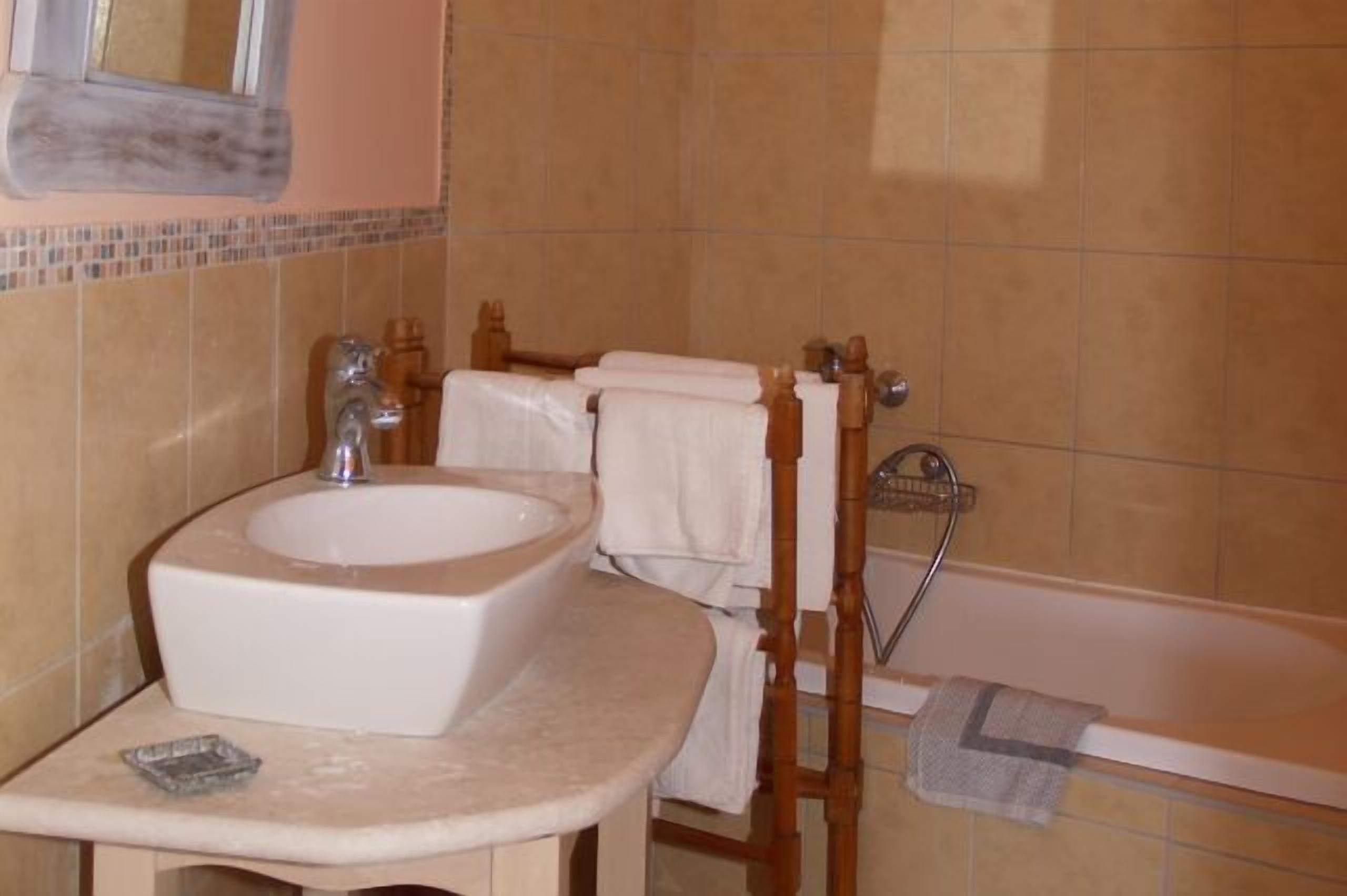 Un bagno con lavandino, specchio e vasca da bagno.