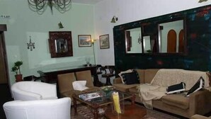 A living room with a sofa, armchairs, a coffee table, and a mirror. - Cretan Village (Agios Nikolaos)