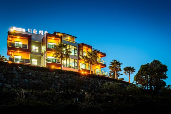 A multi-story hotel with a modern design, featuring balconies and large windows.