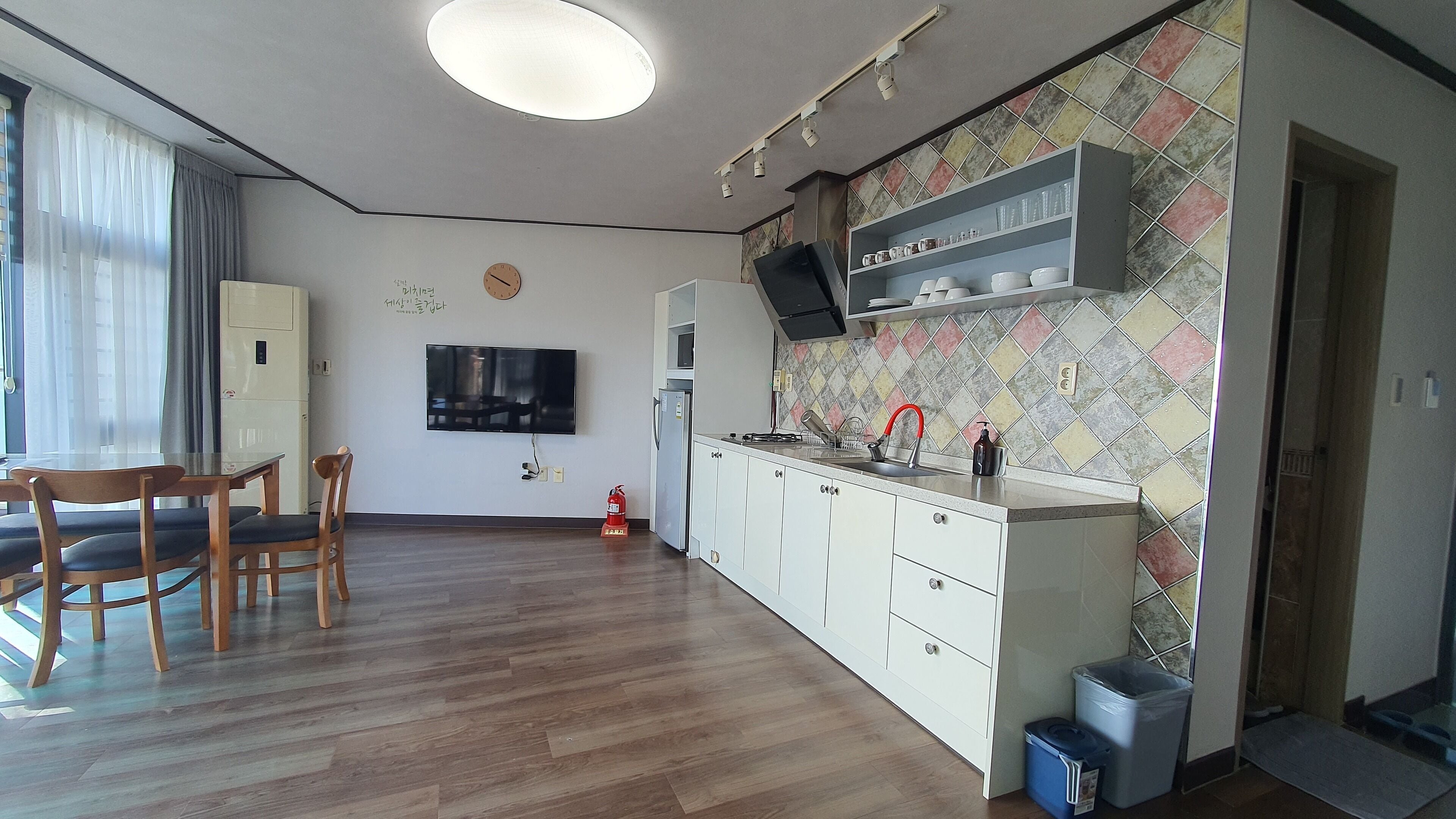 A modern kitchen with white cabinets, a built-in microwave, and a tiled backsplash.
