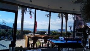 A room with large windows, a pool table, and a view of the ocean. - Beewool Chaewool (Seogwipo)