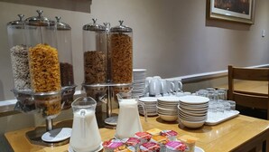 A breakfast buffet setup with cereal, milk, and yogurt containers. - Waverley Guest House (Inverness)
