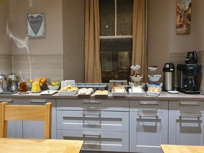 A breakfast buffet setup with various food items and a coffee machine. - Waverley Guest House (Inverness)