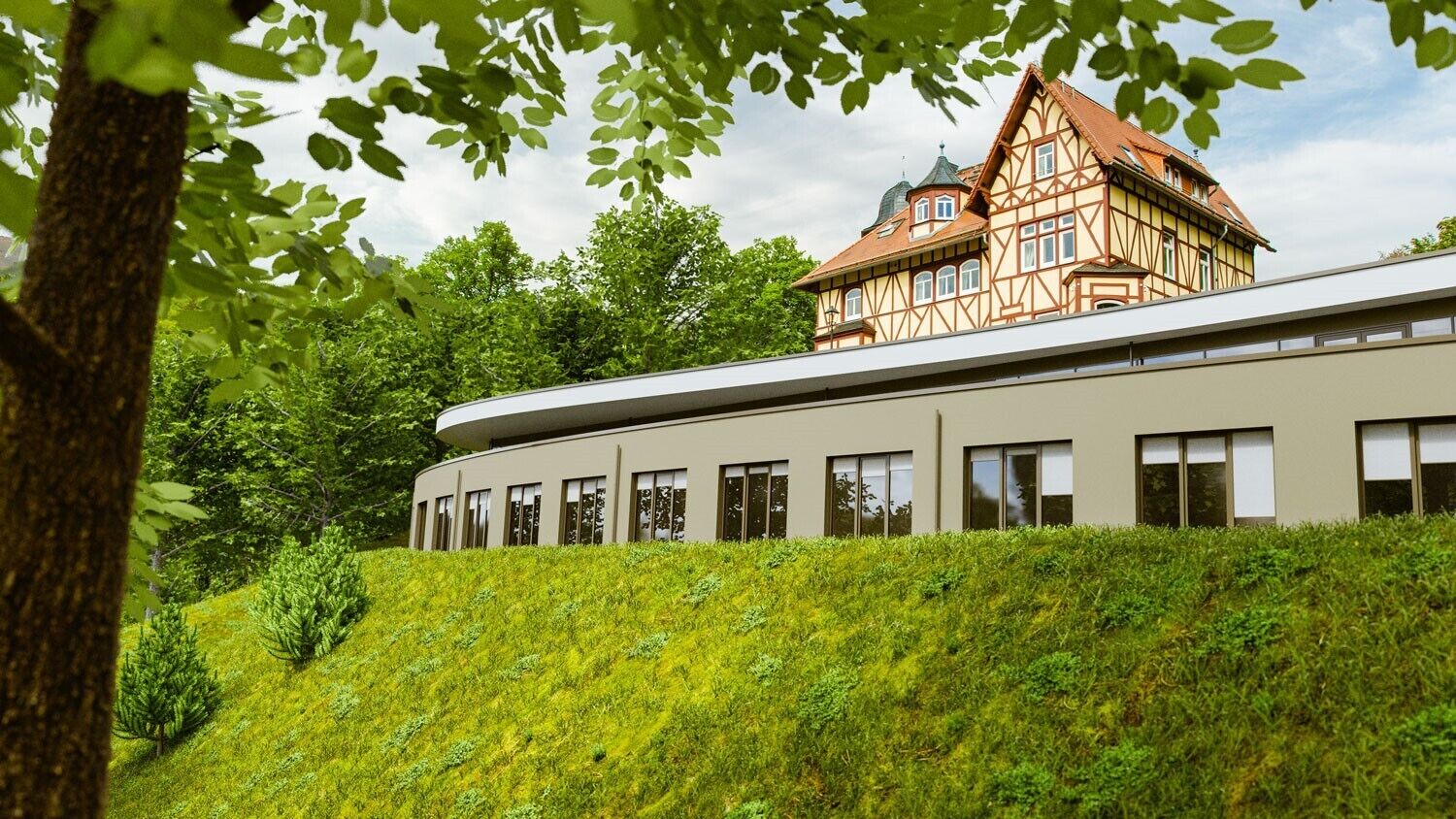 Ein modernes Gebäude mit einem traditionellen Fachwerkhäuschen im Hintergrund.