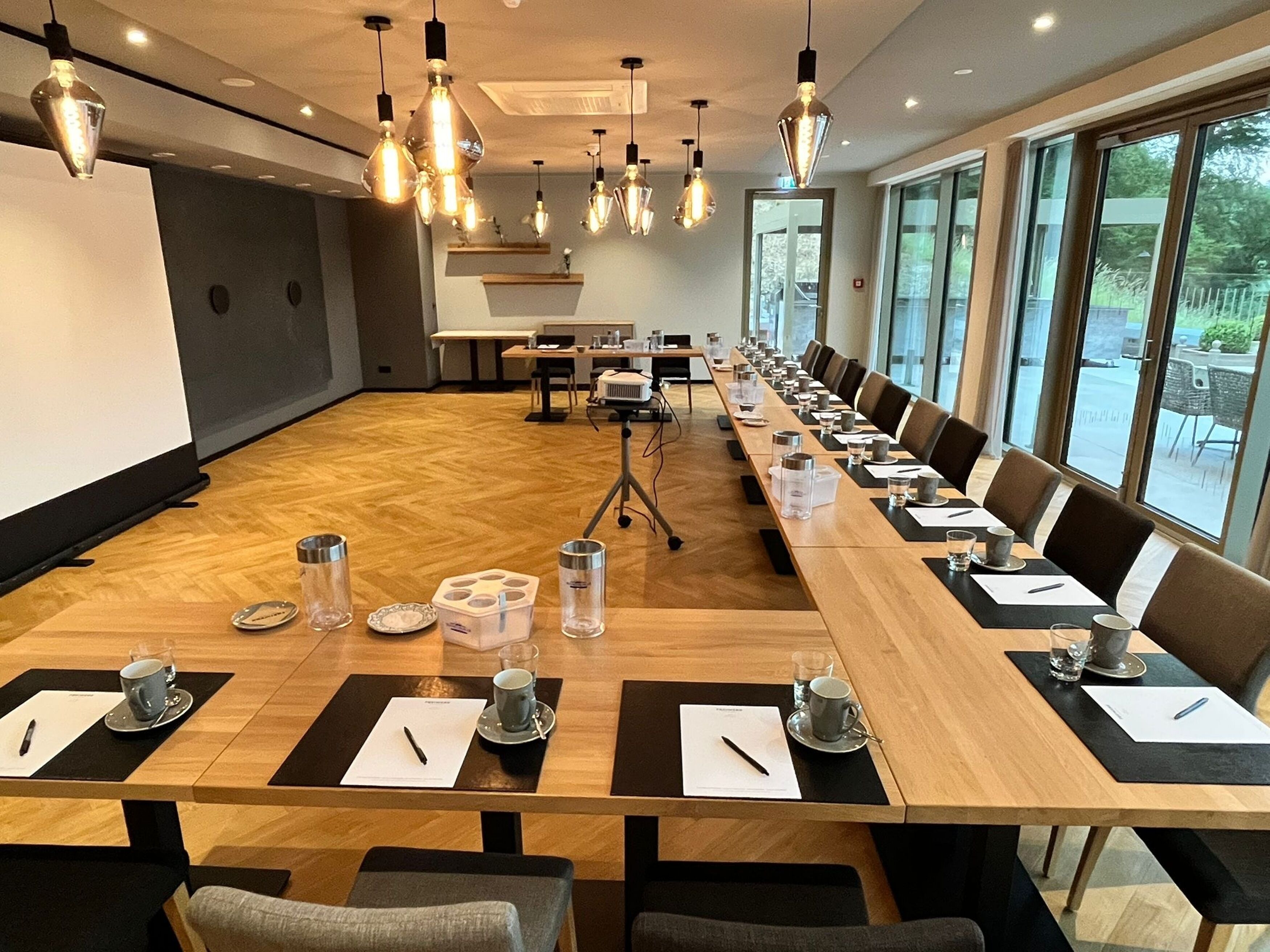A conference room with a long table, chairs, and overhead lighting.