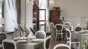 A formal dining room with chandeliers, white chairs, and a wooden cabinet. - Dwór Prezydencki Boutique Hotel & SPA (Tarnow)
