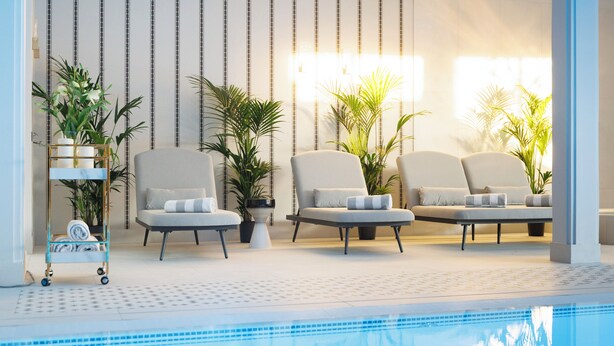 A poolside area with lounge chairs, potted plants, and a towel cart. - Dwór Prezydencki Boutique Hotel & SPA (Tarnow)