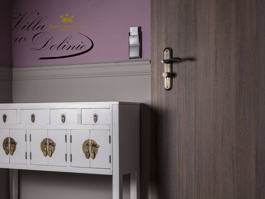 A white cabinet with multiple compartments and a door with a metal handle.