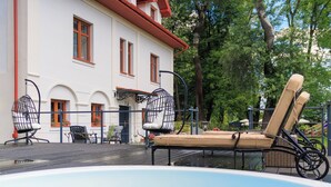 A pool area with lounge chairs and a hot tub, surrounded by a white building with red accents and trees. - Dwór Prezydencki Boutique Hotel & SPA (Tarnow)