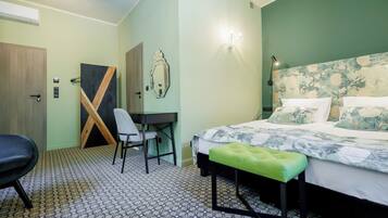 Una habitación de hotel con una cama, un escritorio, una silla y un banco.