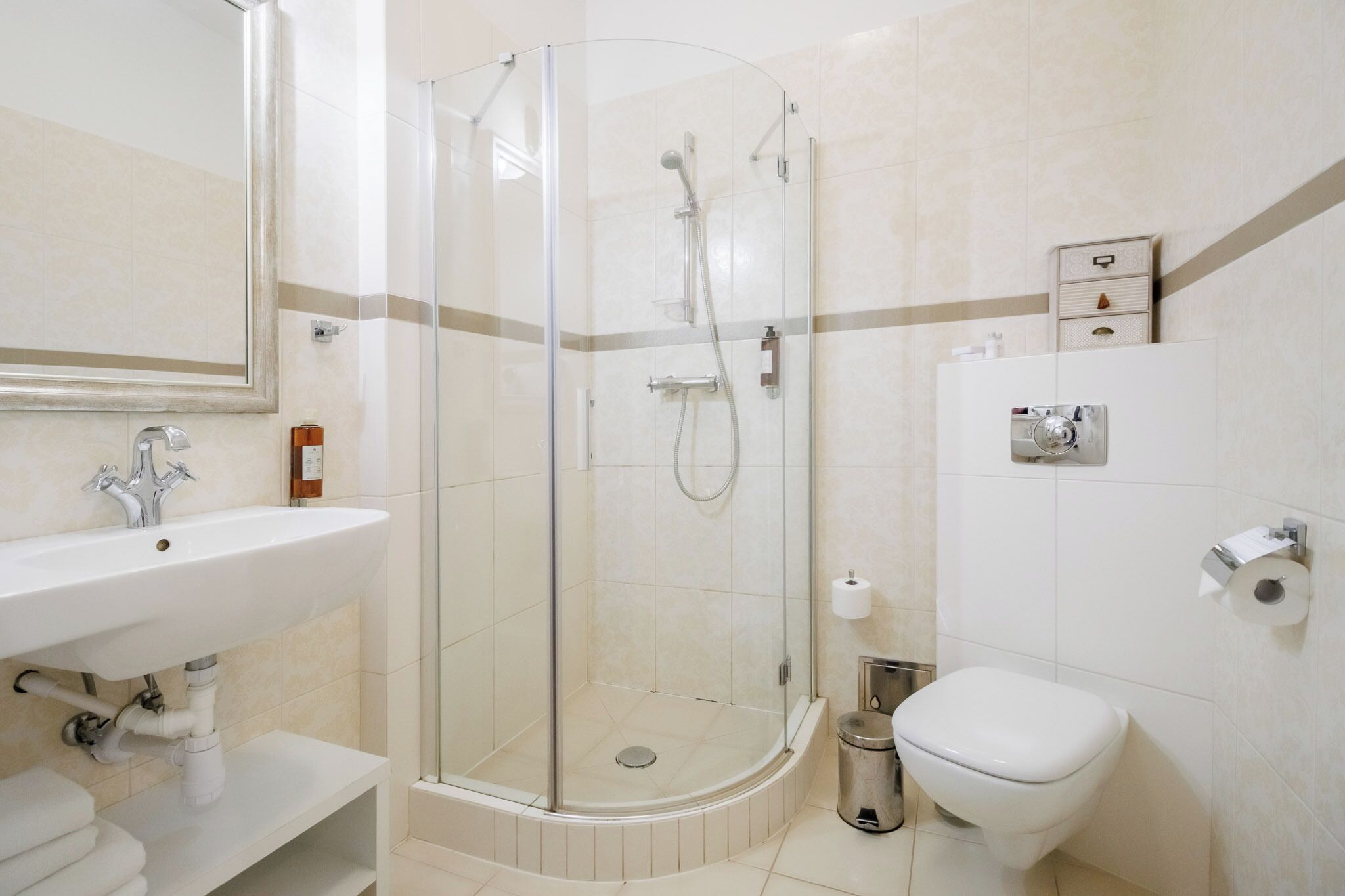 Ein modernes Badezimmer mit einer Duschkabine, einem Waschbecken und einer Toilette.