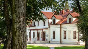 A white building with a red roof, a covered porch, and a paved entrance. - Dwór Prezydencki Boutique Hotel & SPA (Tarnow)