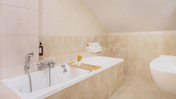 A modern bathroom with a large bathtub, a separate shower area, and a toilet.