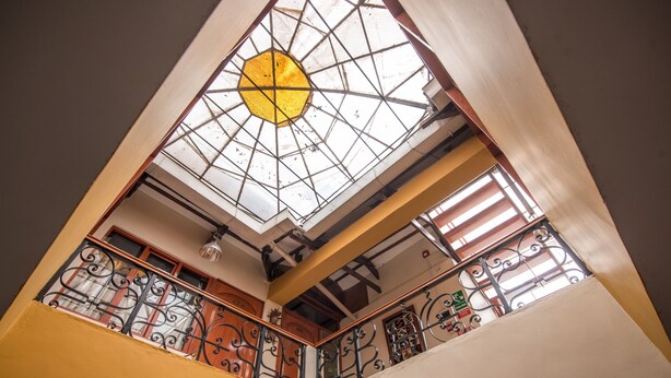 A view of a building's interior with a skylight, metal railings, and wooden elements. - Ayenda Posada Inn (Cusco)