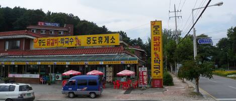 A building with a yellow signboard and a blue van parked in front.