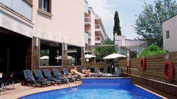 Piscina a l'aire lliure, para-sols i gandules