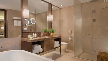 A modern bathroom with a freestanding bathtub, a glass-enclosed shower, and a vanity with a mirror.