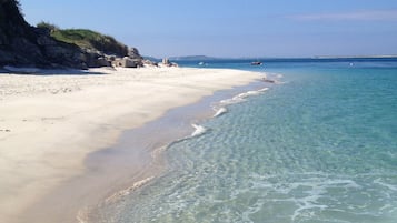 Privéstrand vlakbij, wit zand, ligstoelen aan het strand, parasols