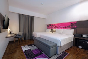 A hotel room with a bed, a desk, a chair, a TV, and a large window with curtains.