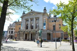 A historic building with a prominent statue in front, labeled "NATIONALTHEATER."