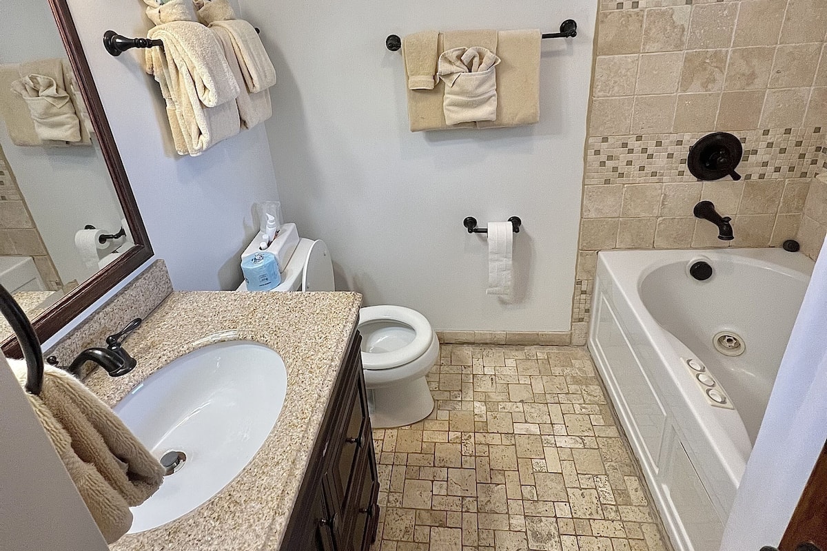 A bathroom with a sink, toilet, bathtub, and a towel rack.