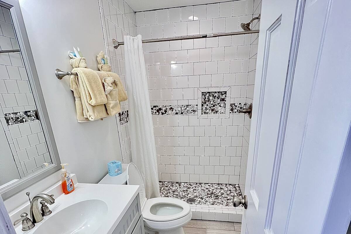 A bathroom with a sink, toilet, and shower.