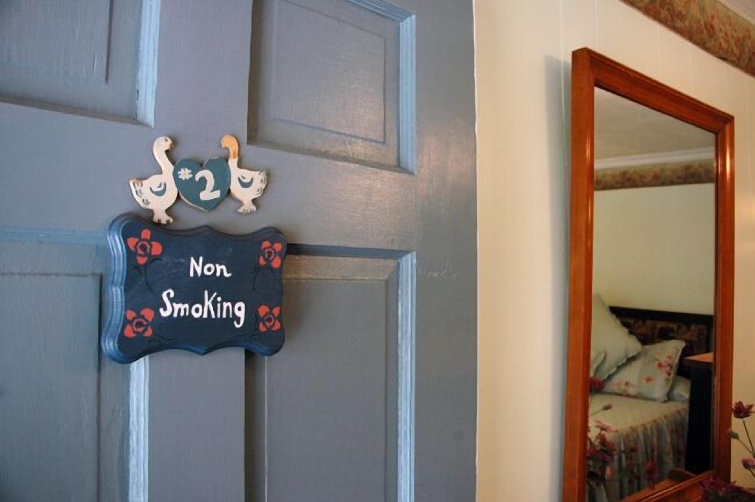 A door with a 'Non Smoking' sign and decorative swans.