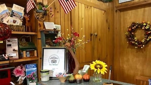 A reception desk with a certificate of excellence, American flags, a wreath, and various decorative items including flowers and pumpkins.