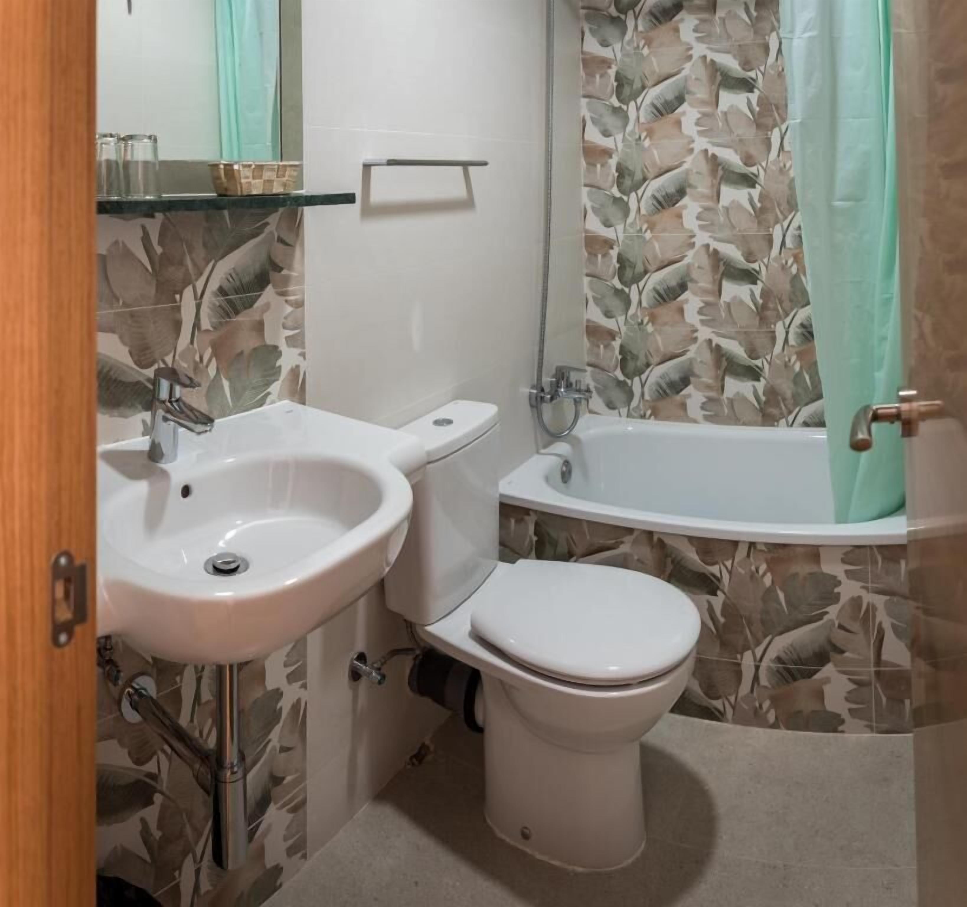 A bathroom with a sink, toilet, and bathtub.