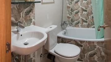 A bathroom with a sink, toilet, and bathtub.