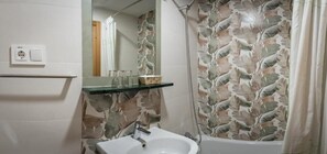 A bathroom with a sink, mirror, and shower curtain. - San Antonio (Madrid)