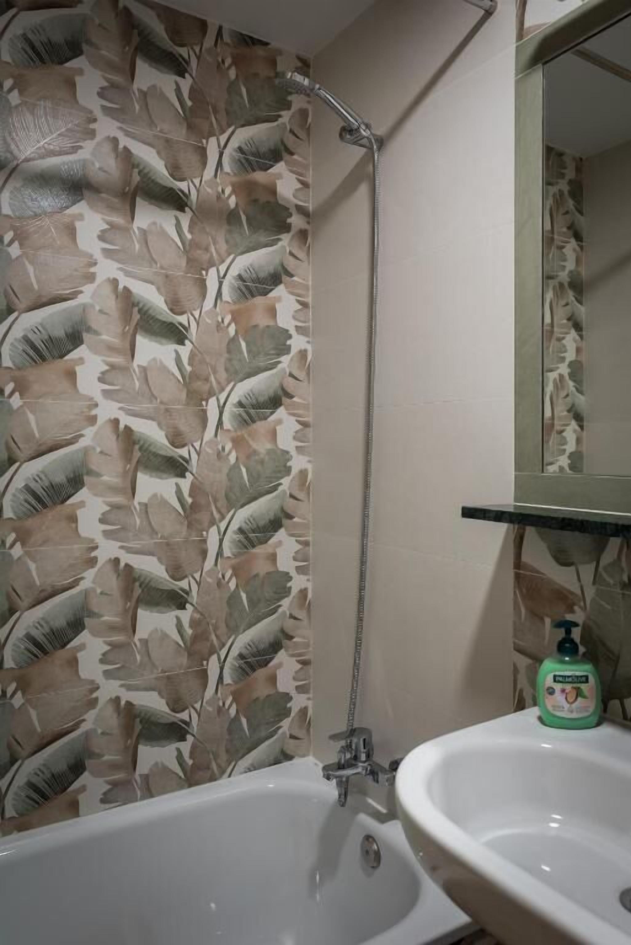 Une salle de bain avec une douche, un lavabo et un miroir.
