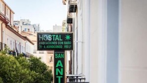 A street view with a sign for 'Hostal' indicating accommodations with a bathroom and TV. - San Antonio (Madrid)