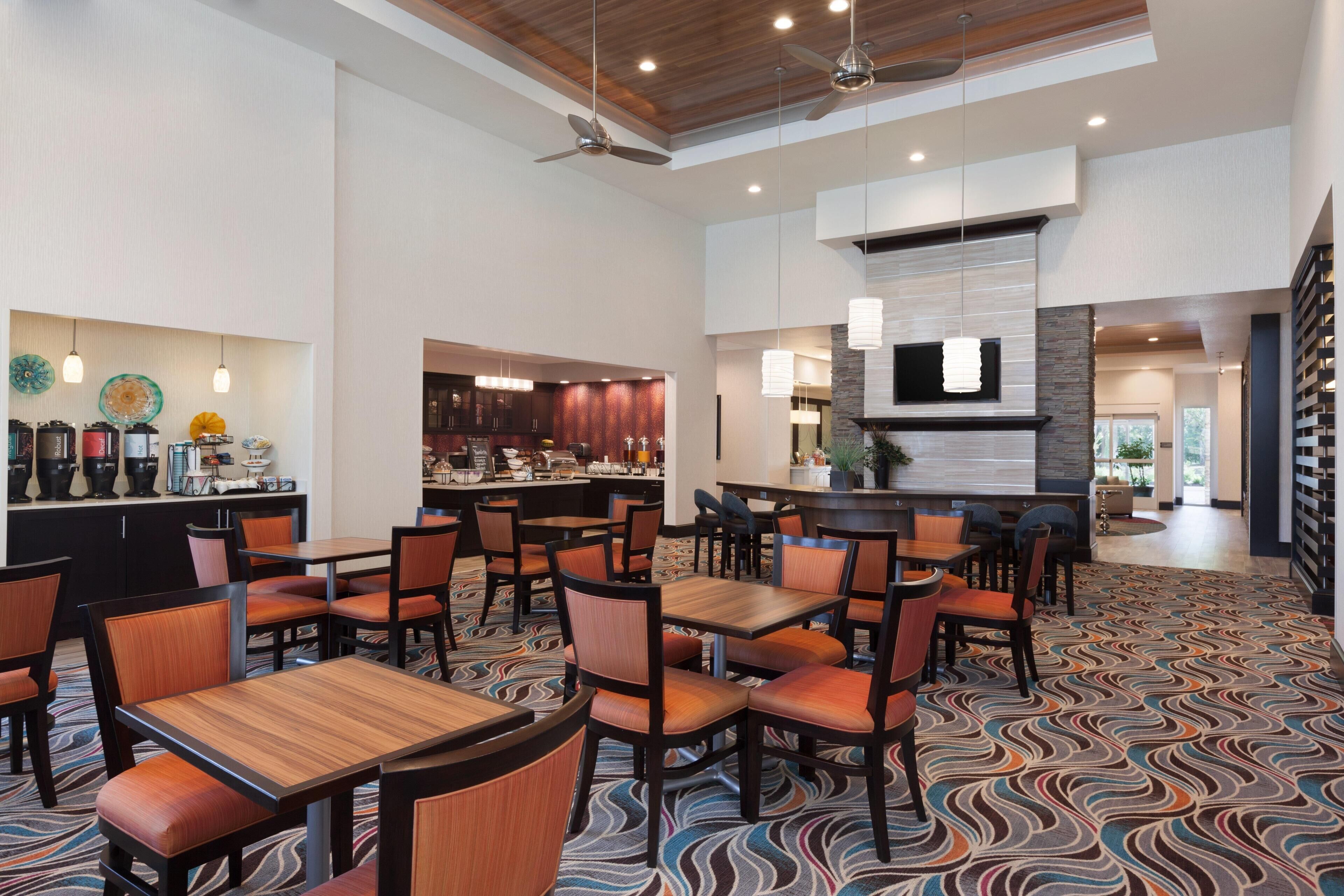 A hotel lobby with a bar, seating area, and a patterned carpet.