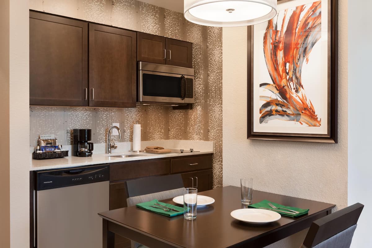 A modern kitchen with a dishwasher, microwave, and coffee maker.