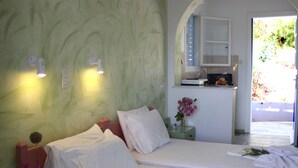 Una habitación de hotel con cama, baño pequeño y vistas al exterior.