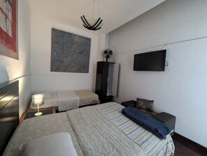 A bedroom with a bed, bedside tables, a TV, a painting, and a wardrobe. - Hospedaje A verde (Lima)