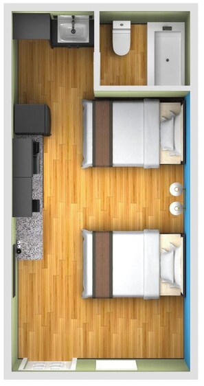 Vue plongeante d’une chambre d’hôtel avec un plancher en bois, deux lits, une petite salle de bain, un lavabo et une fenêtre.
