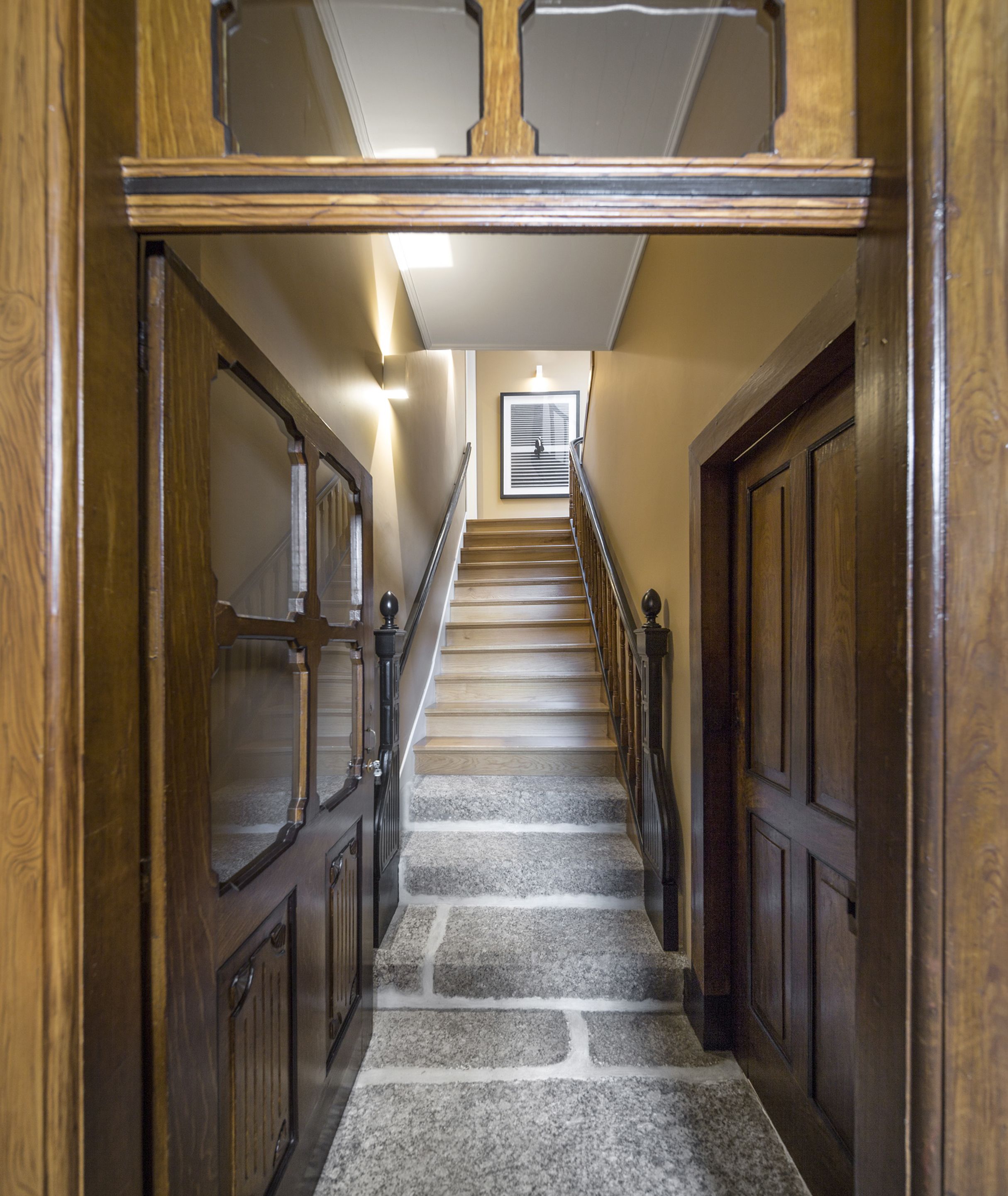 A wooden staircase with stone steps leading to a landing.