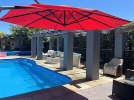 Una piscina al aire libre de temporada, sillones reclinables de piscina