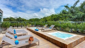 A rooftop deck with sun loungers, a hot tub, and a view of a cityscape. - Estelar Villavicencio Hotel & Centro de Convenciones (Villavicencio)